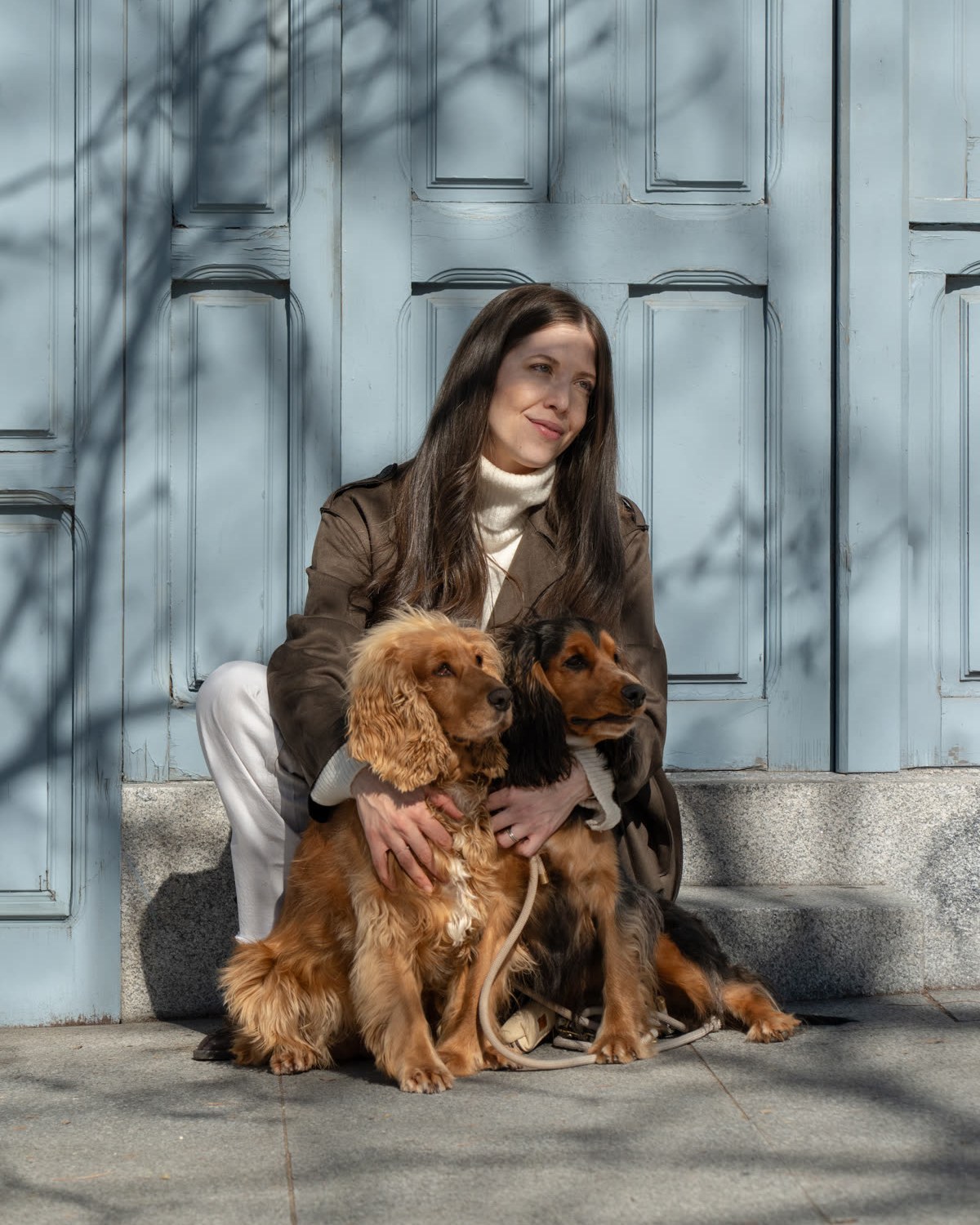 Denisse sitting on a doorstep in Madrid with Alba and Bruno (cocker spaniels)